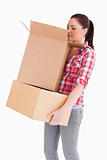 Beautiful woman looking inside a cardboard box while standing