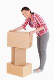 Good looking woman posing with cardboard boxes while standing