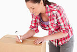 Portrait of a beautiful woman writing on cardboard boxes with a 