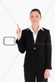 Attractive woman in suit pointing at a copy space