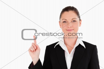 Good looking woman in suit pointing at a copy space
