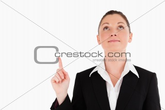 Charming woman in suit pointing at a copy space