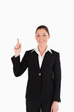 Cute woman in suit pointing at a copy space