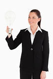 Beautiful woman in suit holding a light bulb while standing