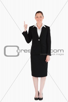Good looking female in suit pointing at a copy space