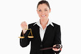 Beautiful woman in suit holding scales of justice and a gavel