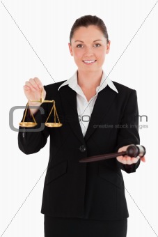 Good looking woman in suit holding scales of justice and a gavel