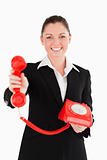 Good looking woman in suit holding a red telephone