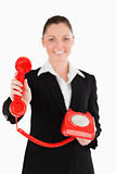 Beautiful woman in suit holding a red telephone