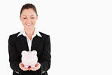 Gorgeous woman in suit holding a pink piggy bank