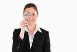 Charming woman in suit holding a magnifying glass