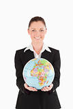 Pretty woman in suit holding a globe