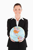 Good looking female in suit holding a globe