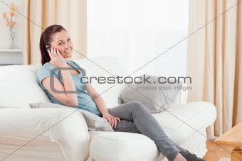 Beautiful woman on the phone while sitting on a sofa