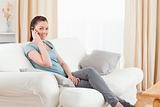 Attractive woman on the phone while sitting on a sofa