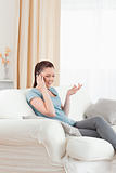 Gorgeous woman on the phone while sitting on a sofa