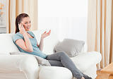 Lovely woman on the phone while sitting on a sofa