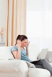 Attractive upset woman gambling with her computer while sitting 