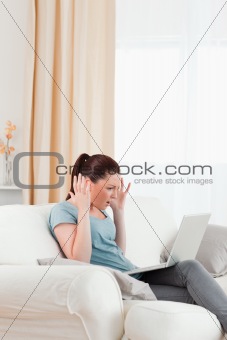 Attractive upset woman gambling with her computer while sitting 