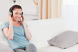Attractive woman relaxing with headphones while sitting on a sof