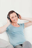 Cute woman relaxing with headphones while sitting on a sofa