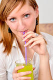 Beautiful young woman drinks juice