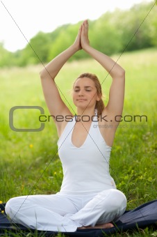 Meditation in nature - Cute young girl meditates outdoor on a gr
