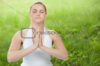 Meditation in nature - Cute young girl meditates outdoor on a gr