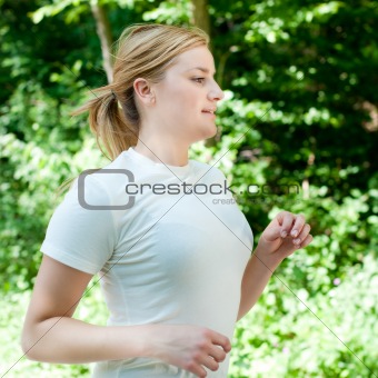 Attractive young woman on a run in nature