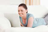 Attractive woman relaxing with her laptop while lying on a sofa