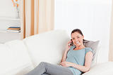 Beautiful woman on the phone while lying on a sofa