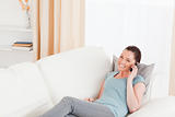 Attractive woman on the phone while lying on a sofa