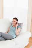 Good looking woman on the phone while lying on a sofa