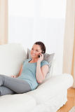 Charming woman on the phone while lying on a sofa