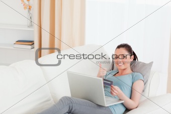 Attractive female making an online payment with her credit card 