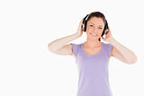 Charming woman posing with headphones while standing