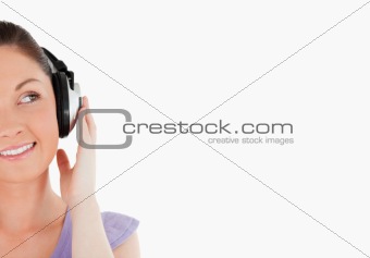 Portrait of a charming woman posing with headphones while standi