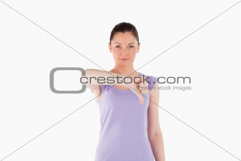 Good looking woman pointing her thumb down while standing