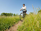 Young girl riding a bike on a field path - offroad