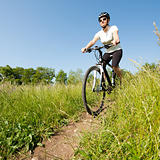 Young girl riding a bike on a field path - offroad