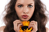 natural girl with long hair holding a sunflower