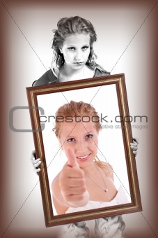 woman on black and white, holding a decorative frame and standing inside it with thumb up, studio shot