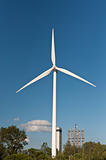 Large Wind Turbine with Trees and Blue Sky