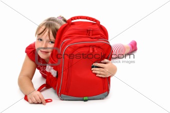 Happy girl lying on floor hugging red school bag smiling isolated on white