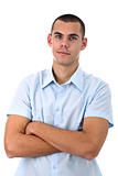 Young man in blue shirt with arms crossed isolated on white