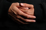 Folded hands of a priest