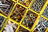 Screws, bolts, nuts and other carpenter stuff in a yellow plastic toolbox