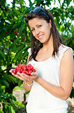 Beautiful young girl picking cherries