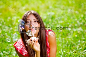 Beautiful woman blowing soap bubbles