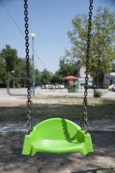 Empty green swing with chain